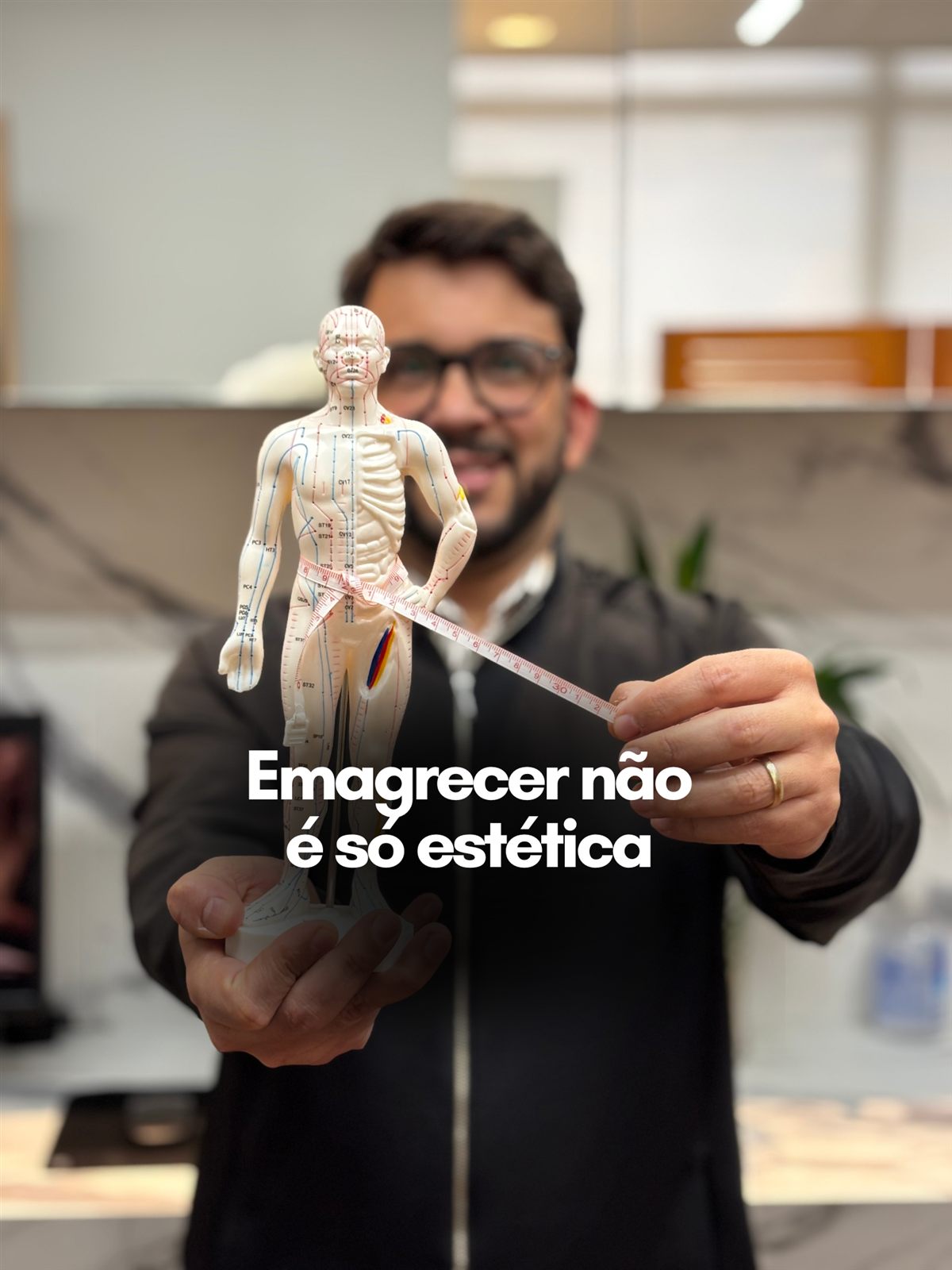 Dr. Kleber Rangel segurando um modelo anatômico com fita métrica, com a frase: emagrecer não é só estética